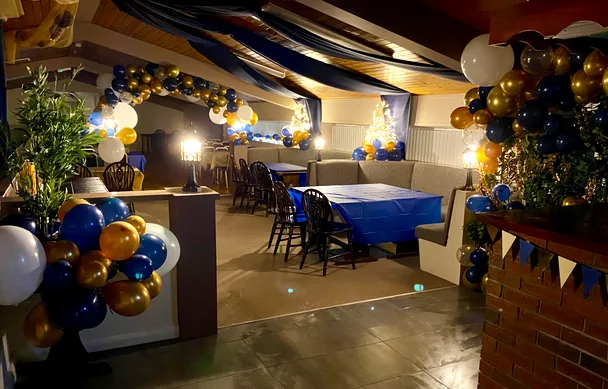 The bar dressed for a party, with balloon arches and a draped ceiling